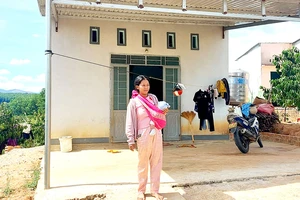 Chị Y Xuyên (xã Đắk Long, huyện Đắk Hà) bên căn nhà ở khu tái định cư