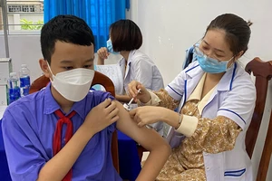 Nhân viên y tế tiêm vaccine Covid-19 cho học sinh