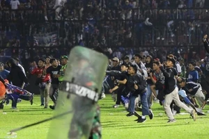 Cổ động viên tràn xuống sân vận động Kanjuruhan ở thành phố Malang, tỉnh Đông Java, Indonesia, tối 1-10, gây ra tình trạng hỗn loạn. Ảnh: AP