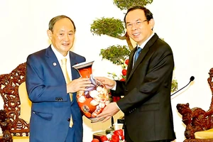 Bí thư Thành ủy TPHCM Nguyễn Văn Nên tặng quà lưu niệm Nguyên Thủ tướng Nhật Bản Suga Yoshihide. Ảnh: VIỆT DŨNG