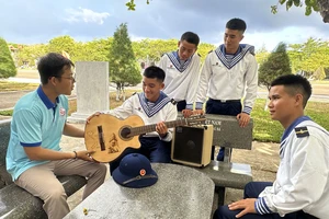 Phóng viên Nguyễn Tam Nguyên (ngoài cùng bên trái) trao gửi đàn guitar tới các chiến sĩ tại đảo Trường Sa