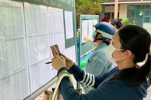 Phụ huynh xem danh sách học sinh lớp 1 tại Trường Tiểu học Phan Đăng Lưu (quận 8, TPHCM) sáng 1-8. Ảnh: CAO THĂNG