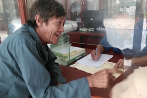 Ông Nguyễn Trung Kỳ (65 tuổi, thôn Thái An) phấn khởi khi được cán bộ xã Vĩnh Hải hướng dẫn thủ tục làm giấy tờ đất đai