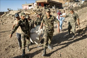 Binh sĩ thuộc lực lượng vũ trang Hoàng gia Maroc di chuyển thi thể nạn nhân vụ động đất ra ngoài. Nguồn: TTXVN