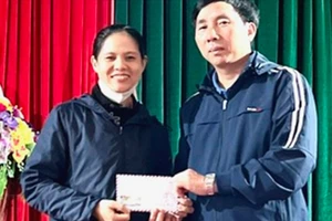 Chị Trần Thị Thành (vợ anh Nguyễn Đình Thiên) tiếp nhận số tiền 13 triệu đồng của bạn đọc Báo SGGP hỗ trợ. Ảnh: DƯƠNG QUANG