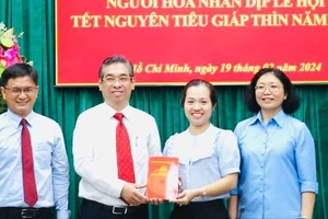 Phó Bí thư Thành ủy TPHCM Nguyễn Phước Lộc trao tặng tiền lì xì cho Quỹ an sinh, khuyến học quận 5. Ảnh: VIỆT DŨNG