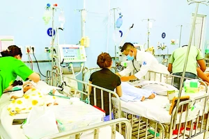 Bác sĩ Bệnh viện Nhi đồng 1, TPHCM thăm khám bệnh nhi mắc sốt xuất huyết. Ảnh: QUANG HUY