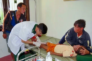 Bác sĩ quân y BĐBP tỉnh Thừa Thiên Huế tại trạm xá quân dân y xã A Đớt sơ cứu cho cháu bé bản Ka Lô, huyện Kà Lừm, tỉnh Sekong bị tai nạn