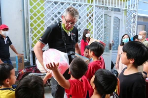 Anh Raymond A Kuschert phát sữa cho trẻ em tại Đà Lạt