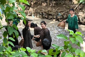 Du khách trải nghiệm tát mương bắt cá tại Khu du lịch Cồn Phụng (huyện Châu Thành, tỉnh Bến Tre)