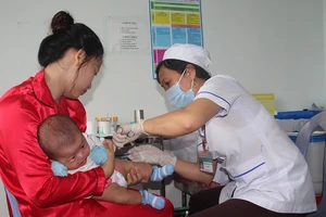 Nhân viên y tế thuộc Trạm Y tế xã Lâm Hải (huyện Năm Căn, tỉnh Cà Mau) tiêm chủng cho trẻ em. Ảnh: TẤN THÁI