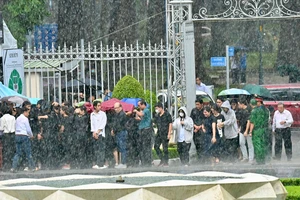 Người dân TPHCM và các tỉnh, thành phố phía Nam đến viếng Tổng Bí thư Nguyễn Phú Trọng dưới mưa. Ảnh: VIỆT DŨNG