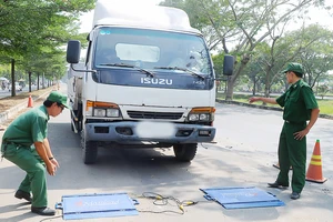 Cân tải trọng xe trên đường Nguyễn Văn Linh, TPHCM. Ảnh: THÀNH TRÍ