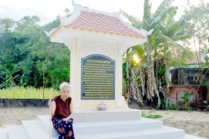 Mẹ Việt Nam anh hùng Nguyễn Thị Thưởng bên di tích trong vườn nhà