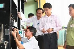 Đoàn liên ngành tỉnh Đắk Lắk thực hiện dán tem trụ bơm xăng dầu ở huyện Cư Mgar. Ảnh: TTXVN