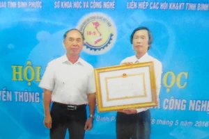 Ông Trần Văn Vân (phải) nhận Huân chương Lao động hạng hai tặng thưởng Sở KH-CN tỉnh Bình Phước