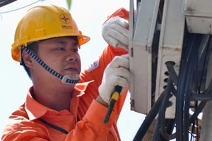 Công nhân ngành điện kiểm tra, sửa chữa hệ thống lưới điện phân phối. Ảnh: VGP