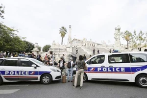 Hành khách tập trung quanh các xe cảnh sát bên ngoài ga xe lửa Saint-Charles ở Marseille sau vụ tấn công ngày 1-10-2017. Ảnh: AP