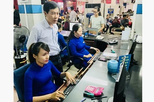 Ông Đỗ Quang Văn (đứng) kiểm tra hệ thống bán vé tại quầy vé ở Ga Sài Gòn. Ảnh: T.BA