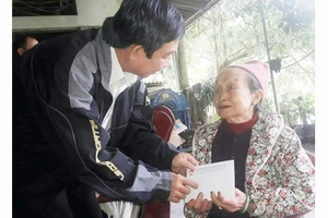 Ông Đỗ Trung Tính trao tiền hỗ trợ bà Nguyễn Thị Hường (ở tỉnh Hòa Bình, có người thân bị lũ cuốn trôi)
