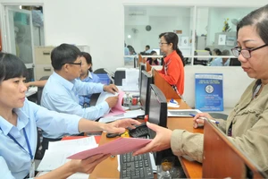 Giải quyết hồ sơ cho người dân tại Công ty cổ phần Cấp nước Gia Định. Ảnh: CAO THĂNG