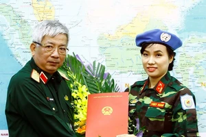 Thượng tướng Nguyễn Chí Vịnh trao Quyết định của Chủ tịch nước cho Thiếu tá Đỗ Thị Hằng Nga. Ảnh: TTXVN