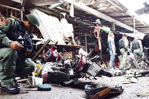 Lực lượng chức năng kiểm tra hiện trường vụ đánh bom xe máy tại chợ Pimolchai ở quận Muang, Yala, vào sáng 21-1. Ảnh: Bangkok Post 