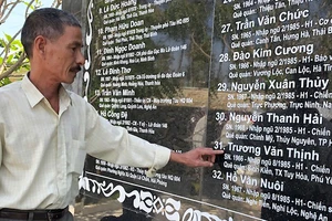 Ông Trương Văn Cẩn bên tấm bia liệt sĩ khắc tên em trai mình