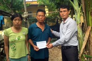 Đại diện Báo SGGP trao tiền hỗ trợ gia đình chị Nhất, anh Sinh