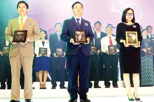 Ông Lê Viết Hải - Chủ tịch HĐQT, Tổng Giám đốc Công ty Cổ phần Tập đoàn Xây dựng Hòa Bình (đứng giữa) nhận bảng vàng chứng nhận tại buổi lễ tôn vinh 