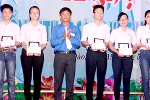Trần Hữu Việt (thứ 3 từ trái sang) tặng học bổng cho học sinh nghèo của địa phương
