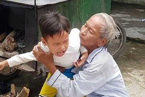Ông Chinh đang dỗ dành đứa cháu nội tật nguyền