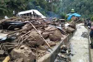 Người dân kiểm tra một địa điểm sau khi bị lũ quét qua tại làng Saladi, Mandailing Natal, tỉnh Bắc Sumatra ngày 13-10