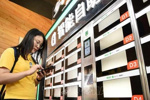 Người dân mua đồ ăn nhanh bằng dịch vụ thanh toán qua điện thoại ở Trùng Khánh, Trung Quốc ngày 23-8-2018. Ảnh: THX