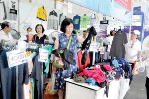  Khách hàng chọn mua quần áo ở một hội chợ tổ chức tại Nhà thi đấu Phú Thọ, TPHCM. Ảnh: THÀNH TRÍ