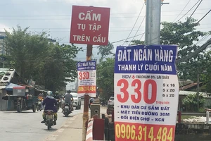 Bảng quảng cáo ngân hàng thanh lý nền đất giá rẻ treo dày trên đường Đỗ Xuân Hợp (quận 9, TPHCM)
