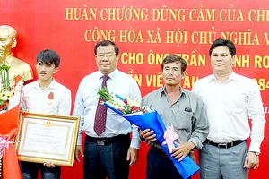 Lãnh đạo tỉnh Quảng Ngãi trao Huân chương Dũng cảm của Chủ tịch nước tặng thưởng anh Trần Thanh Ron (bìa trái)