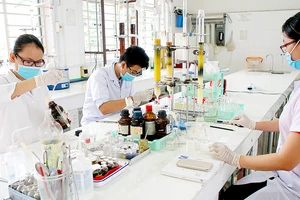 Sinh viên Trường Đại học Sài Gòn nghiên cứu hóa học tạo vi sinh bảo vệ môi trường. Ảnh: HOÀNG HÙNG