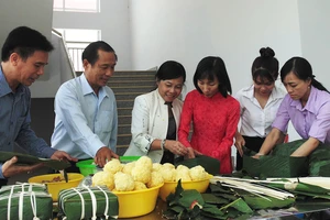 Bà Nguyễn Thị Gái, Chủ tịch Công đoàn ngành giáo dục TPHCM (thứ ba từ trái qua) cùng gói bánh tét với các thầy cô giáo 