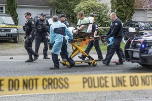 Một người đàn ông được cảnh sát xác định là hung thủ được di chuyển trên băng ca sau khi va chạm với một xe khác. Ảnh: The Seattle Times