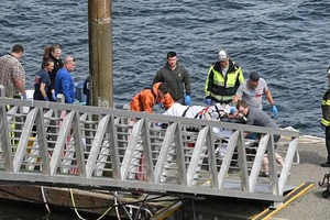 Lực lượng cứu hộ đang chuyển một hành khách bị thương đến xe cứu thương tại bến cảng George Inlet Lodge ở Ketchikan, Alaska. Ảnh: AP