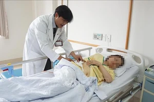 Bệnh nhân Nguyễn Thị Như T được bác sĩ kiểm tra tình hình sức khỏe trước khi xuất viện