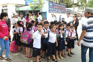 Học sinh Trường Tiểu học An Hội (quận Gò Vấp) được nhân viên một cơ sở bán trú hướng dẫn di chuyển về cơ sở nghỉ trưa 