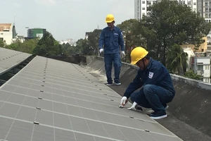 Nhân viên ngành điện lắp đặt điện mặt trời áp mái cho một đơn vị trên địa bàn TPHCM