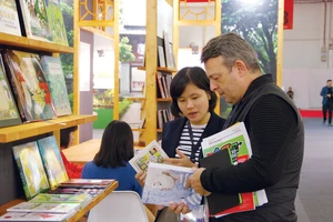 Một đối tác nước ngoài đang tìm hiểu các ấn phẩm của Việt Nam tại Hội sách Frankfurt 2019. Ảnh: HÒA LONG