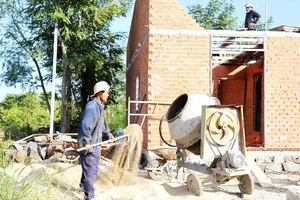 Anh Trần Ngọc Tài (huyện Cư Mgar, tỉnh Đắk Lắk) bên căn nhà đang được xây mới từ “Quỹ tiết kiệm 1.000 đồng”