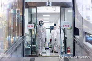  Lực lượng chức năng khử trùng một bệnh viện ở Busan, cách Seoul 450km về phía Đông Nam, ngày 24-2. Ảnh: Yonhap