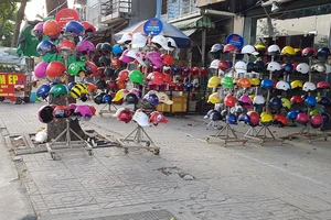 Nón bảo hiểm giá rẻ bày bán tràn lan trên vỉa hè đường Phạm Văn Đồng