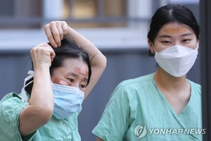 Nhân viên y tế sử dụng băng cá nhân để che vết thương trên mặt do đeo kính bảo hộ trong nhiều giờ trong khi điều trị cho bệnh nhân nhiễm Covid-19 tại Bệnh viện Dongsan ở Daegu vào ngày 4-3. Ảnh: Yonhap