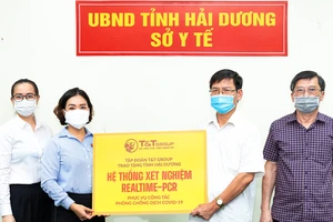 Đại diện Tập đoàn T&T Group (bên trái) trao tặng hệ thống máy xét nghiệm Realtime – PCR cho đại diện Sở Y tế Hải Dương (bên phải)